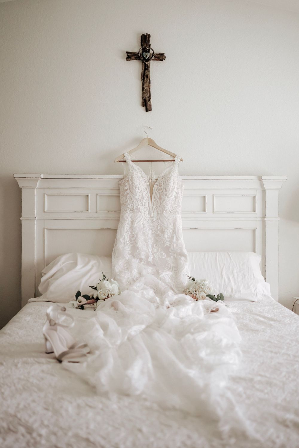 Detail photo of wedding dress under a wooden cross