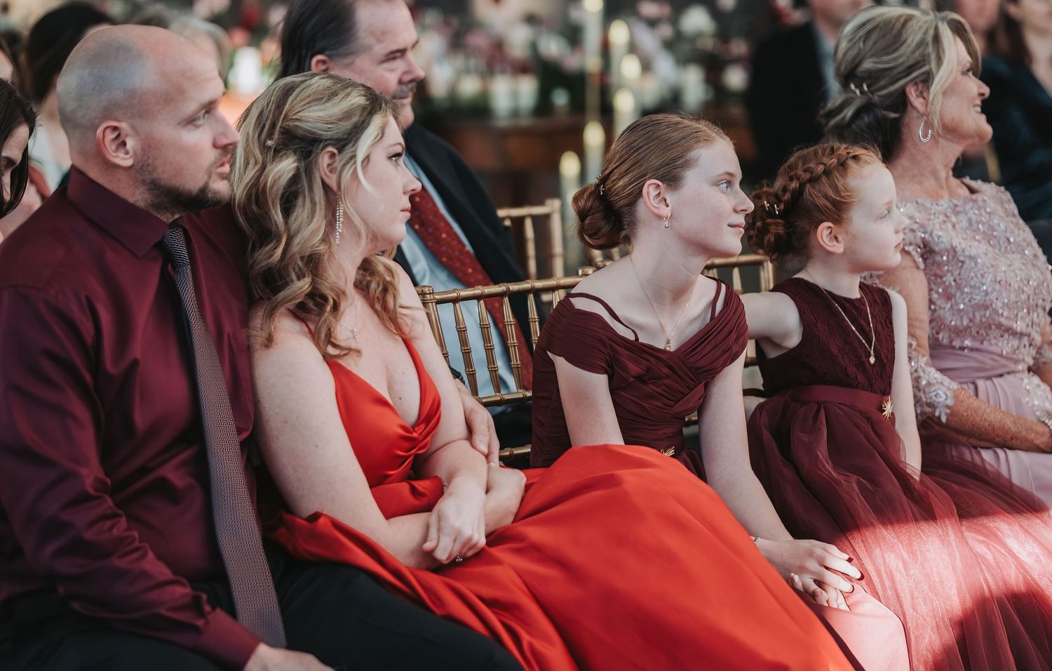 Wedding guests seated in formal attire watching the ceremony proceedings.