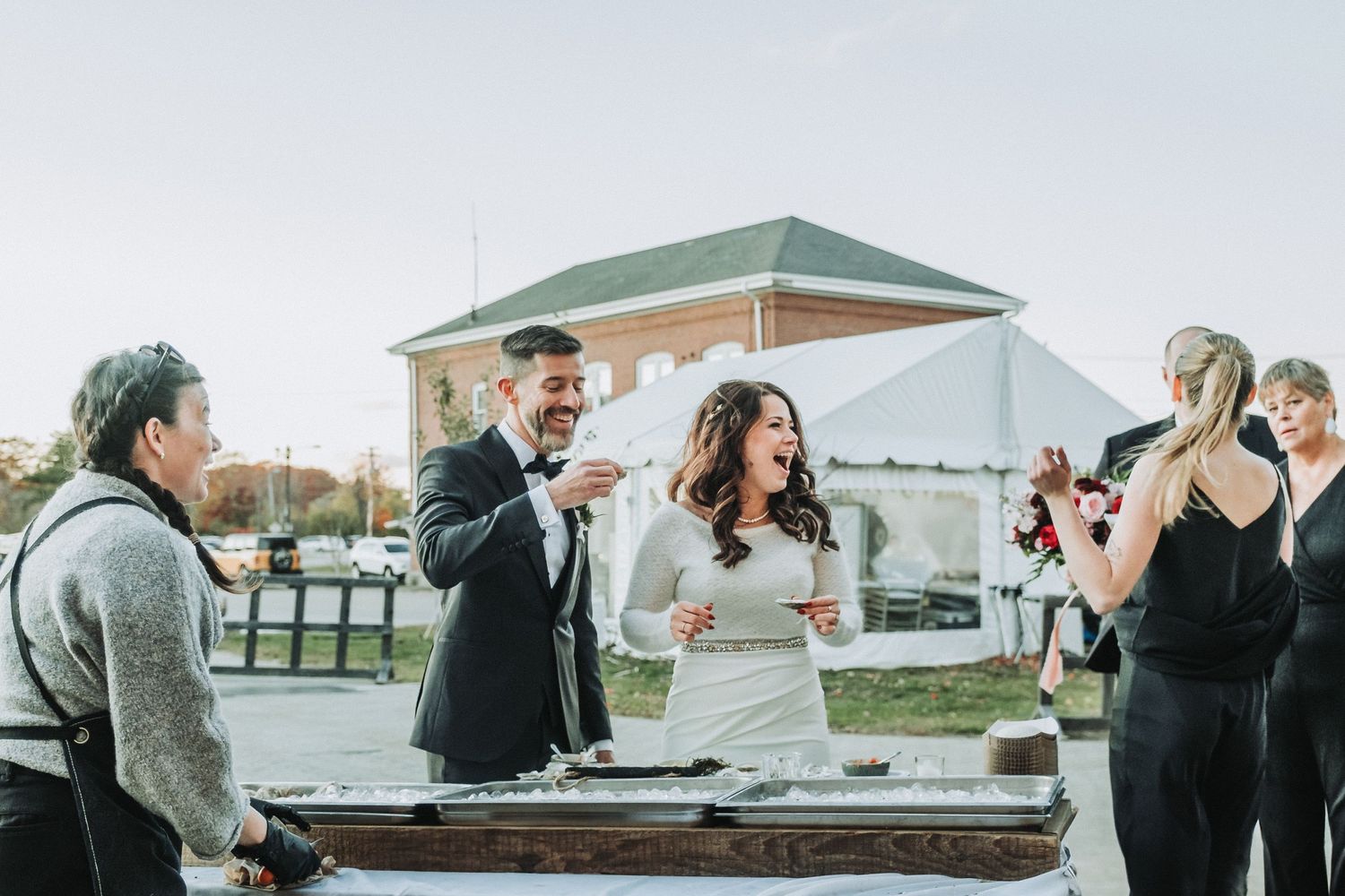 A celebration takes place outdoors with guests gathered around during a wedding reception.