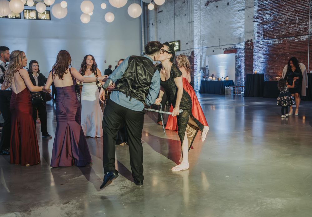 Wedding guests enjoying playful dancing moments during reception in industrial-chic venue.  The venue is Halo at the Point in Portland, ME.