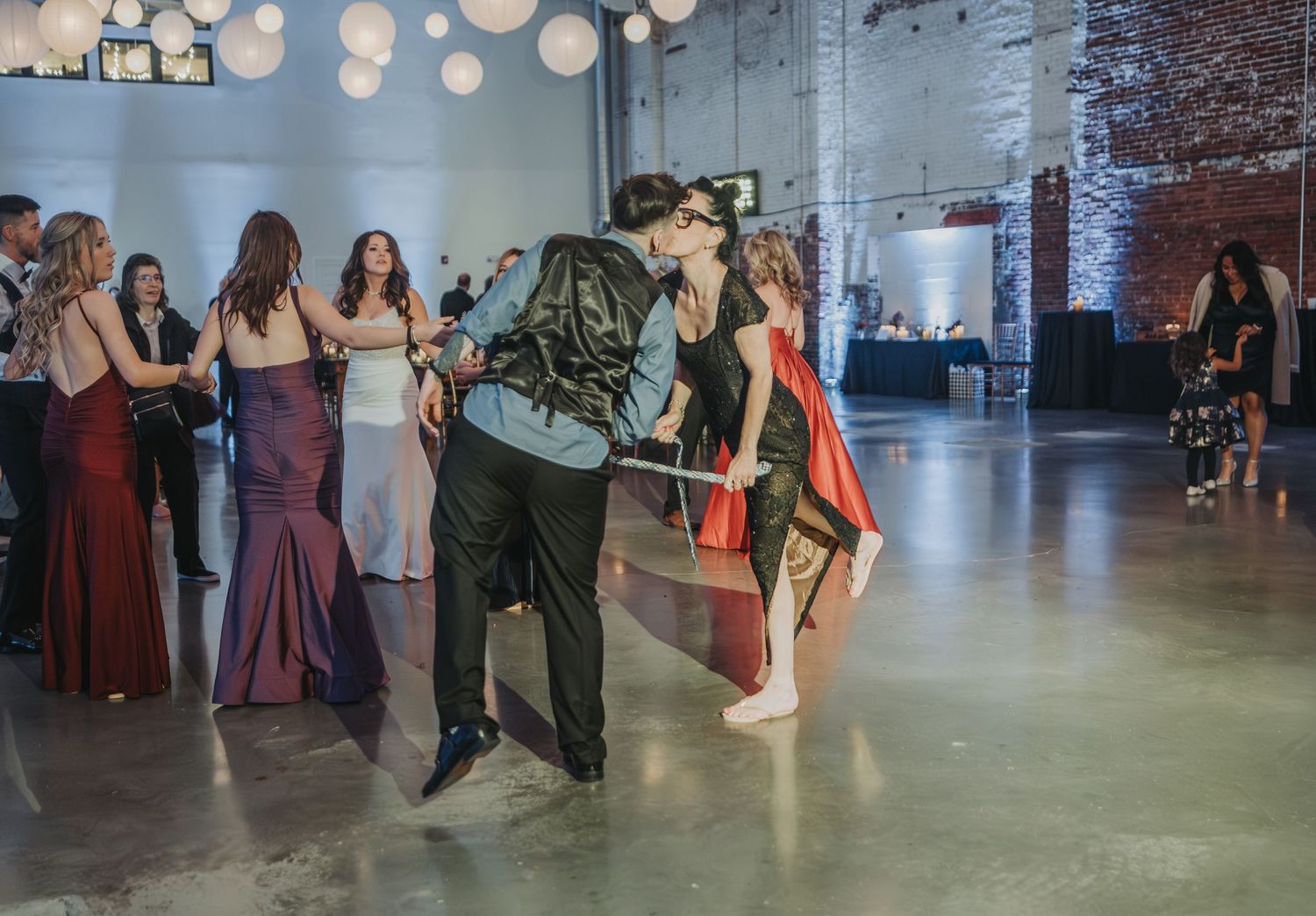 Wedding guests enjoying playful dancing moments during reception in industrial-chic venue.  The venue is Halo at the Point in Portland, ME.