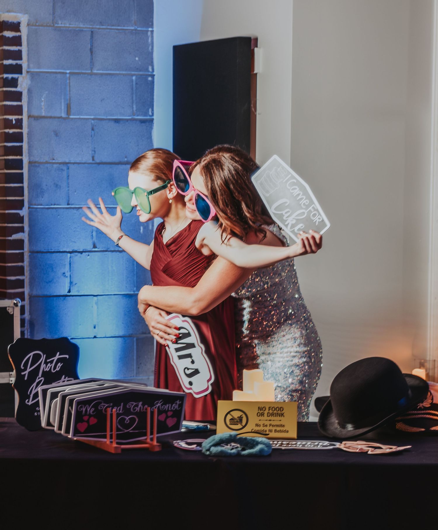 Portland, Maine Wedding guests having fun at DJ booth with props and colorful lighting.