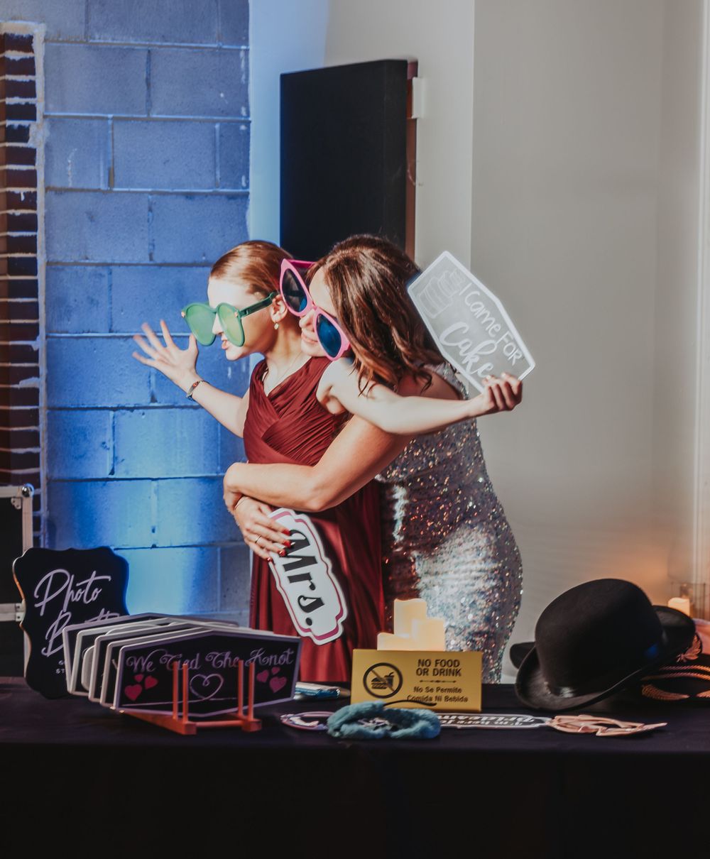 Portland, Maine Wedding guests having fun at DJ booth with props and colorful lighting.
