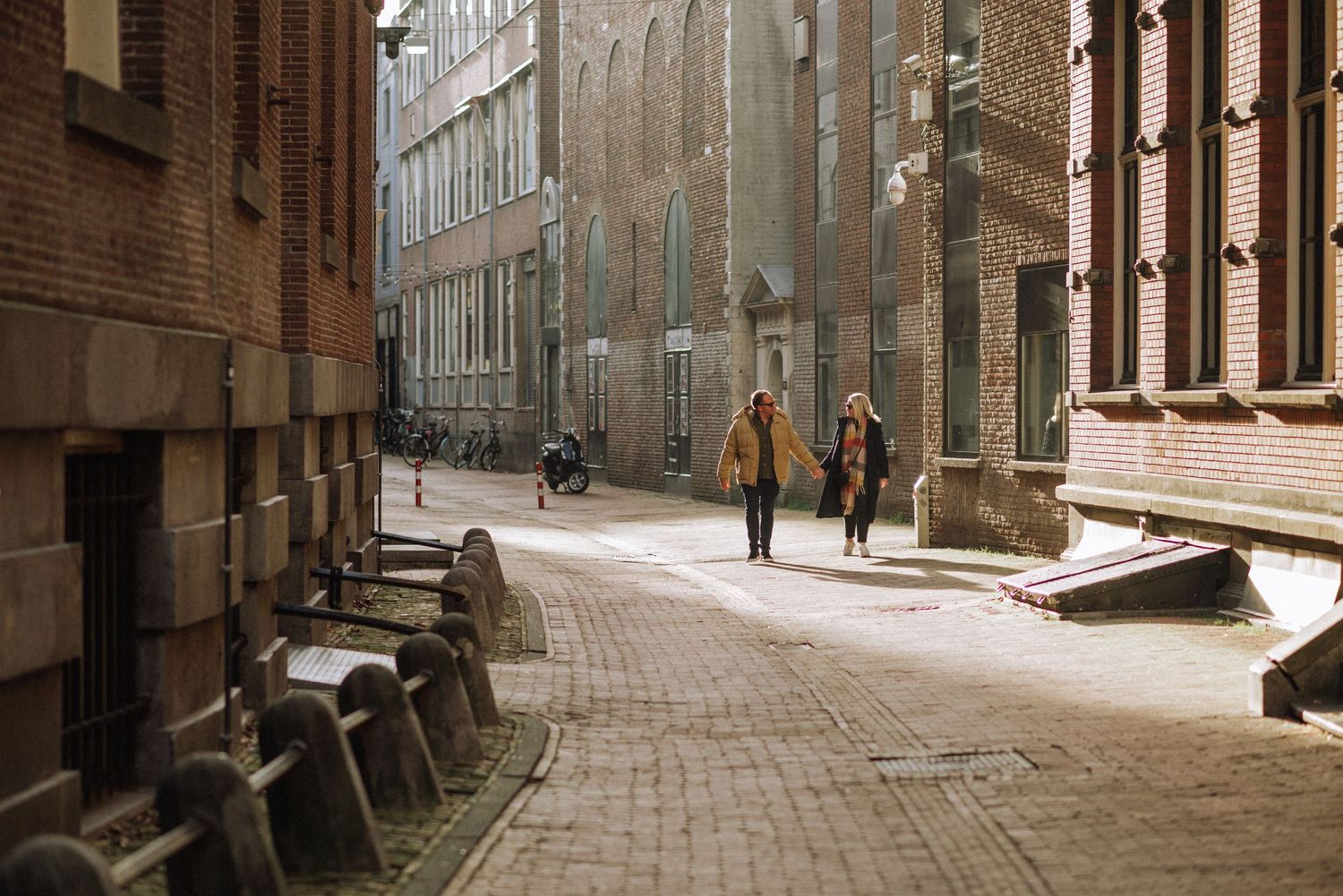 Couple walking together on a quiet street in central Amsterdam, candid urban couple session.