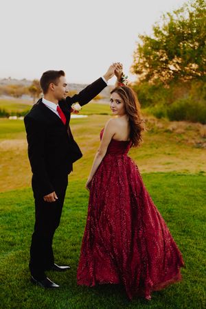 A playful dance sequence on green grass during golden hour.