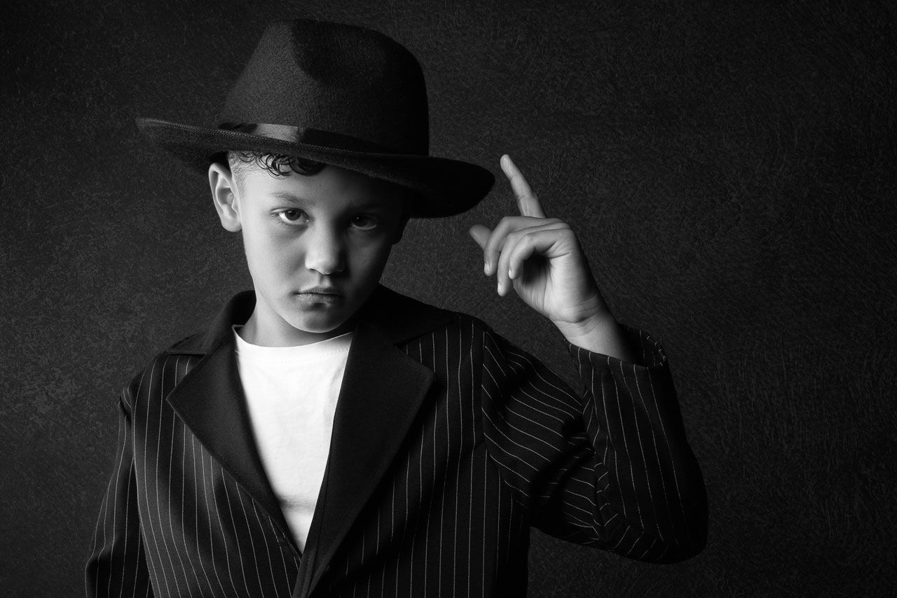 Portret zwarte achtergrond jongen met hoed