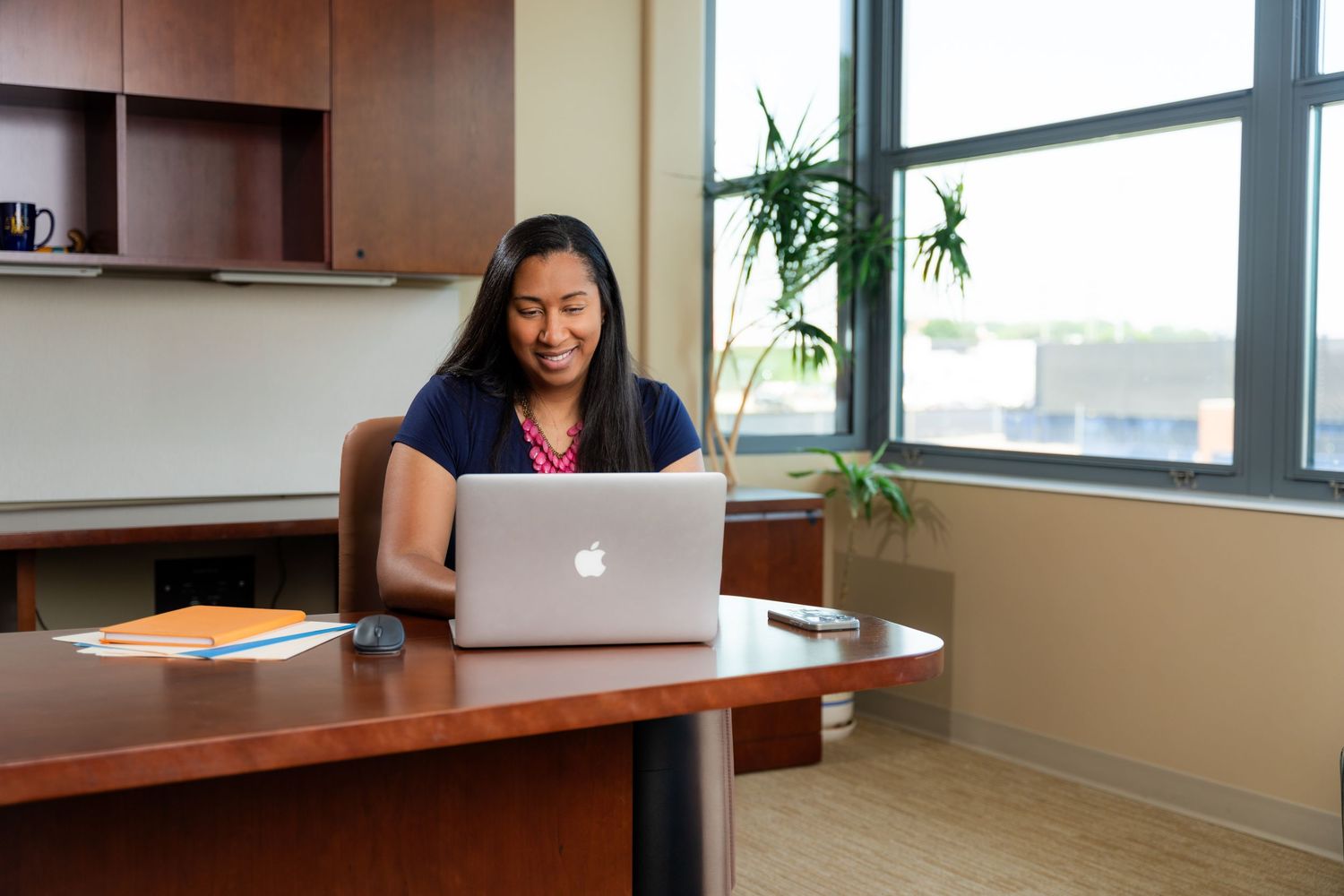 Branding photo for a virtual assistant in the head coach's office at UofM. Studio lighting setup for branding photos in Michigan.