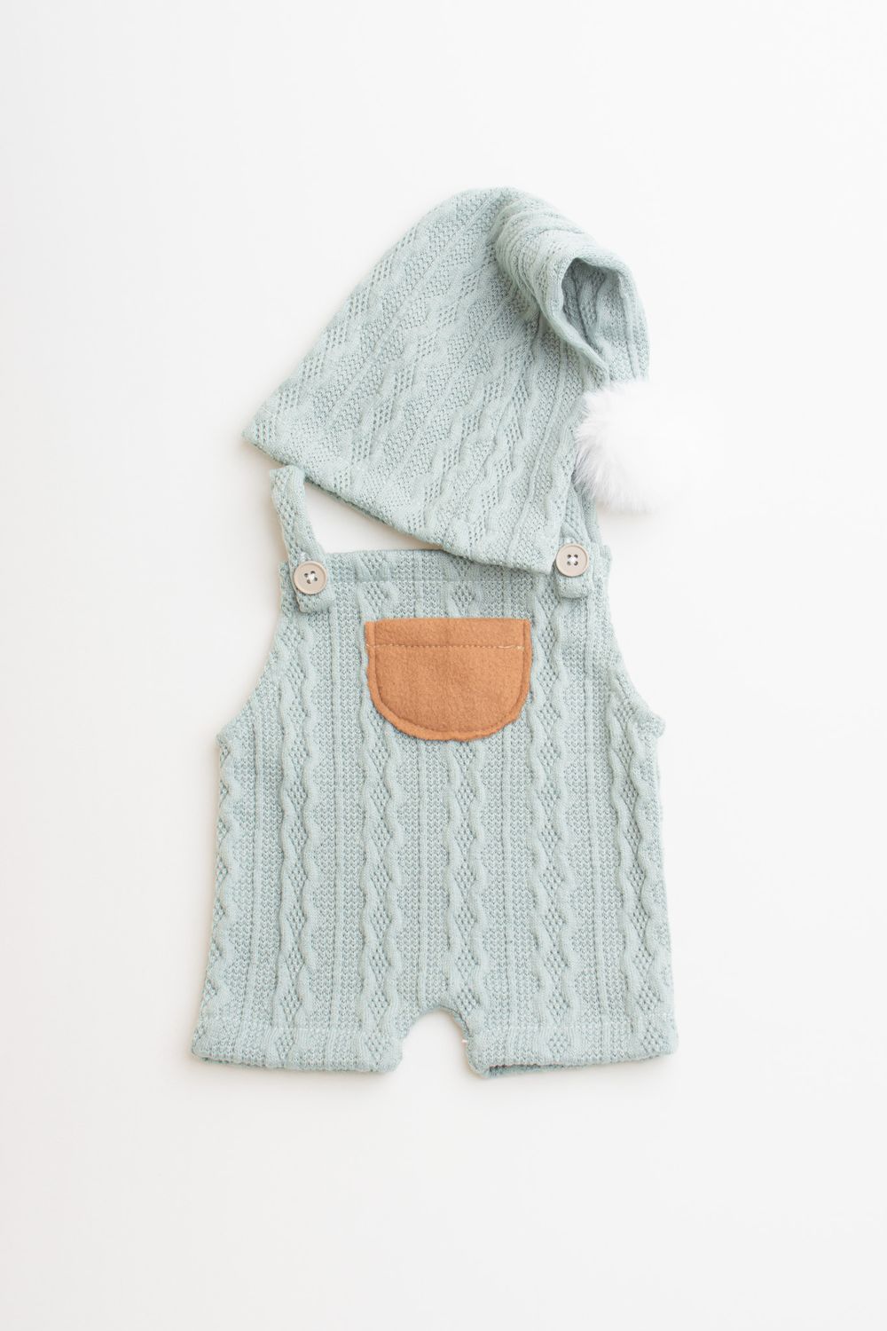Mint green cable knit baby romper with tan leather pocket and matching knit beanie on white background. newbron fotografie