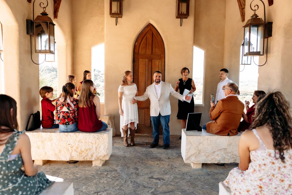 Engagement photo session inside a Spanish-style building with arched doorways and vintage lanterns.