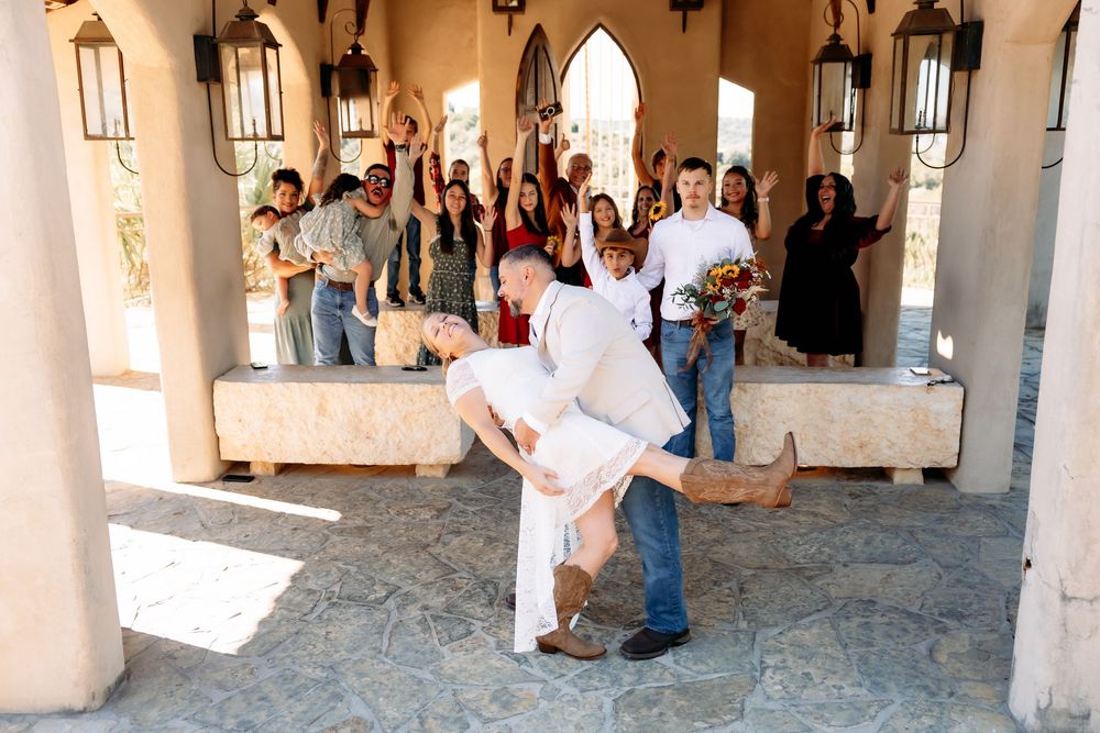 Guests gather in an elegant stone archway corridor during a wedding celebration.