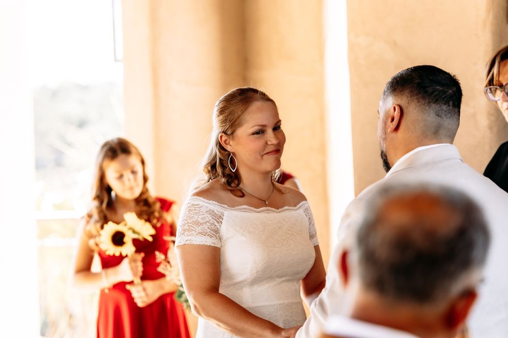 Wedding party members in white and red attire celebrate joyfully during reception festivities.