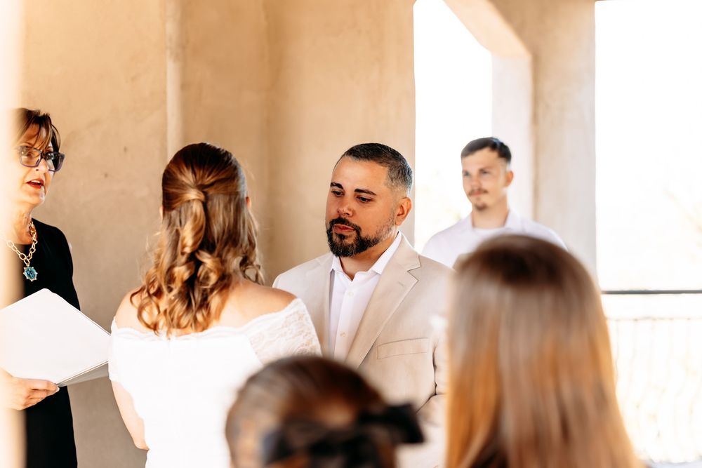 Wedding guests mingle and socialize during a bright indoor reception celebration.