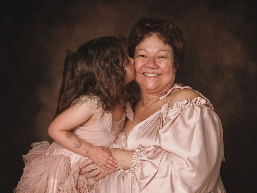 Several candid studio portraits of a mother and child together in soft pink tones and dark backgrounds.