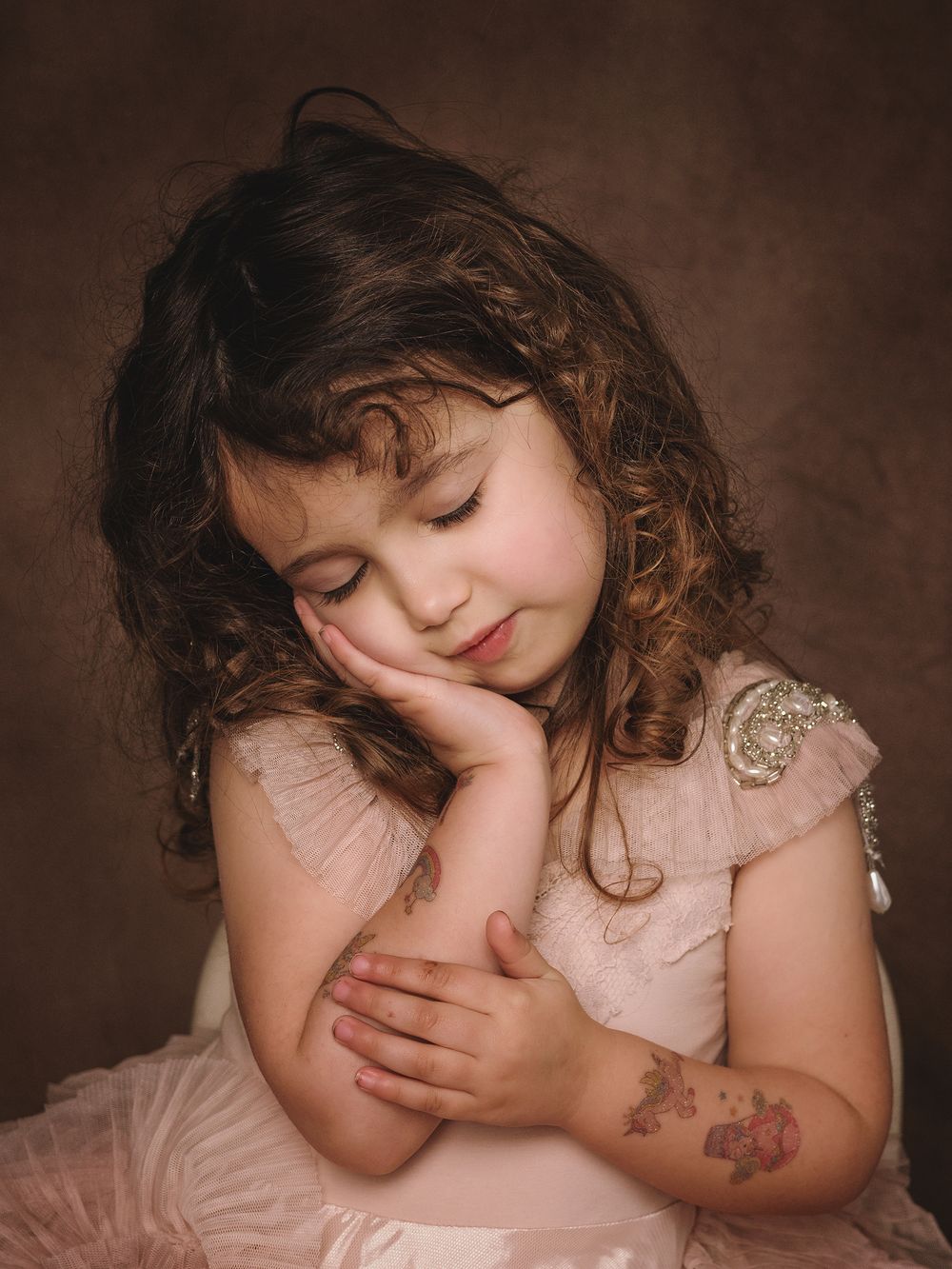 A sleeping figure rests peacefully in a dreamy portrait series with soft brown tones and gentle lighting.
