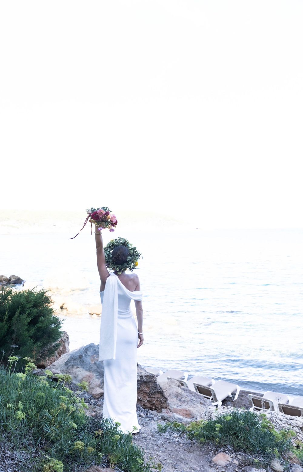Bride with bouquet in hand celebrating her wedding day on the beach
