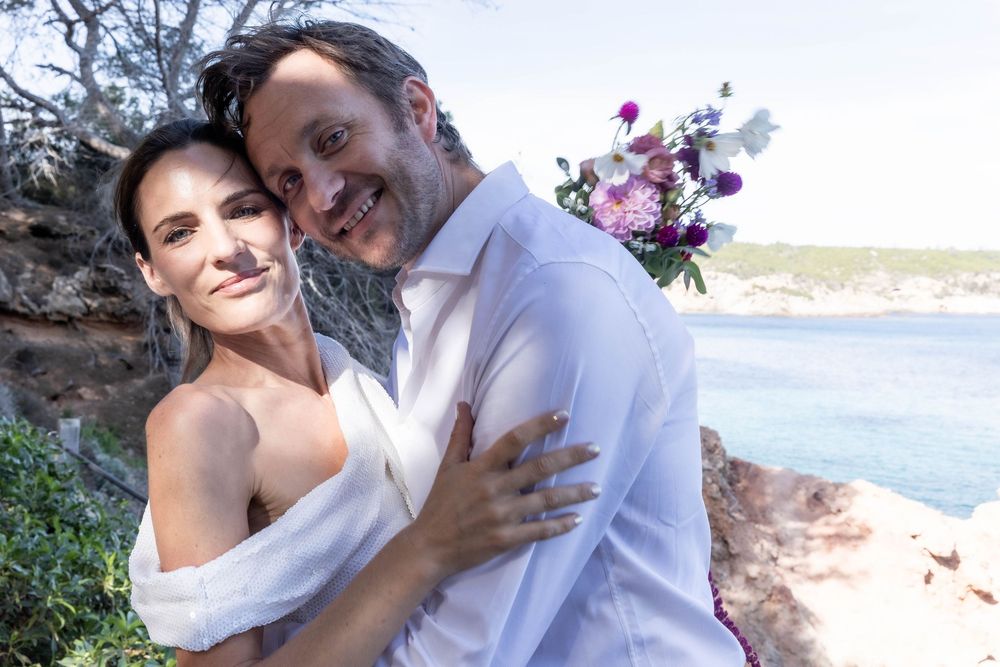 Couple celebrating their wedding on a beach photo shoot