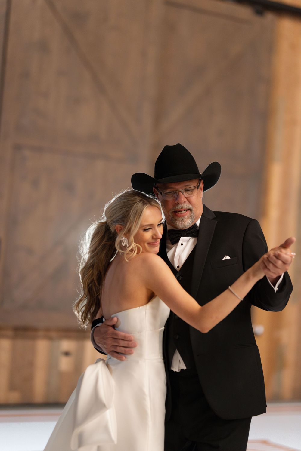 Couple sharing a romantic dance at their western-themed wedding reception.