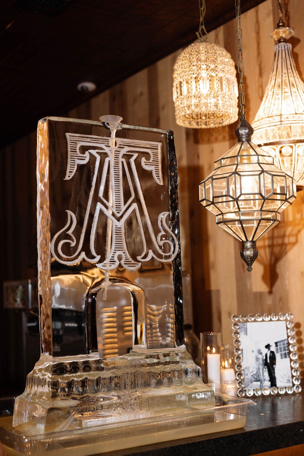 Elegant crystal ice sculpture display of decorative chandeliers at a wedding reception.