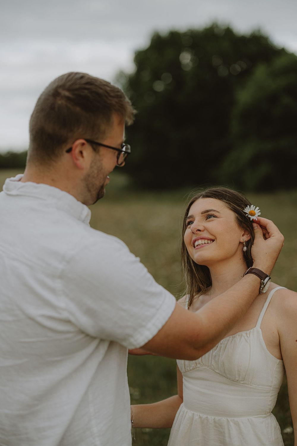 A gentle moment shared between two people as they place flowers in each other's hair.
