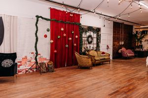 A panoramic view of a theater stage with red curtains, wooden flooring, and theatrical lighting fixtures.
