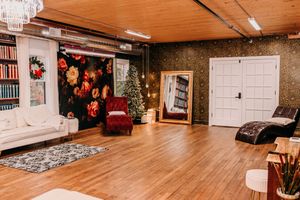 Panoramic view of a cozy basement library with wooden floors, white walls, and holiday decorations.