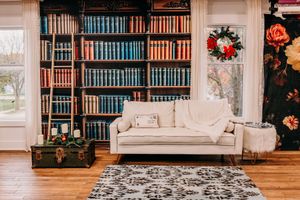 Detailed view of a home library with built-in bookshelves, framed artwork, and festive Christmas decor.