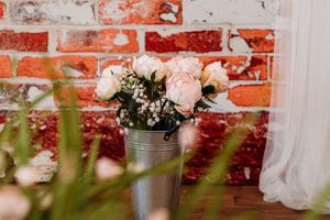 A rustic brick wall with string lights and hanging decorative elements creates a romantic outdoor ambiance. Photography Studio in Wayland