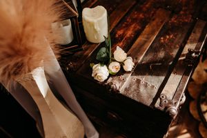 Delicate roses and candles arranged on rustic wooden surface with soft lighting and romantic styling details. Photography Studio in Wayland