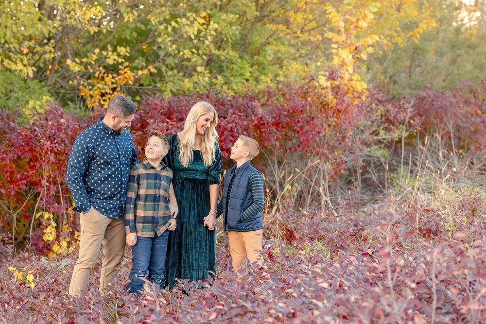 Family portrait session among vibrant red and yellow fall foliage. Clear Lake Photographer. Mason City Photographer.