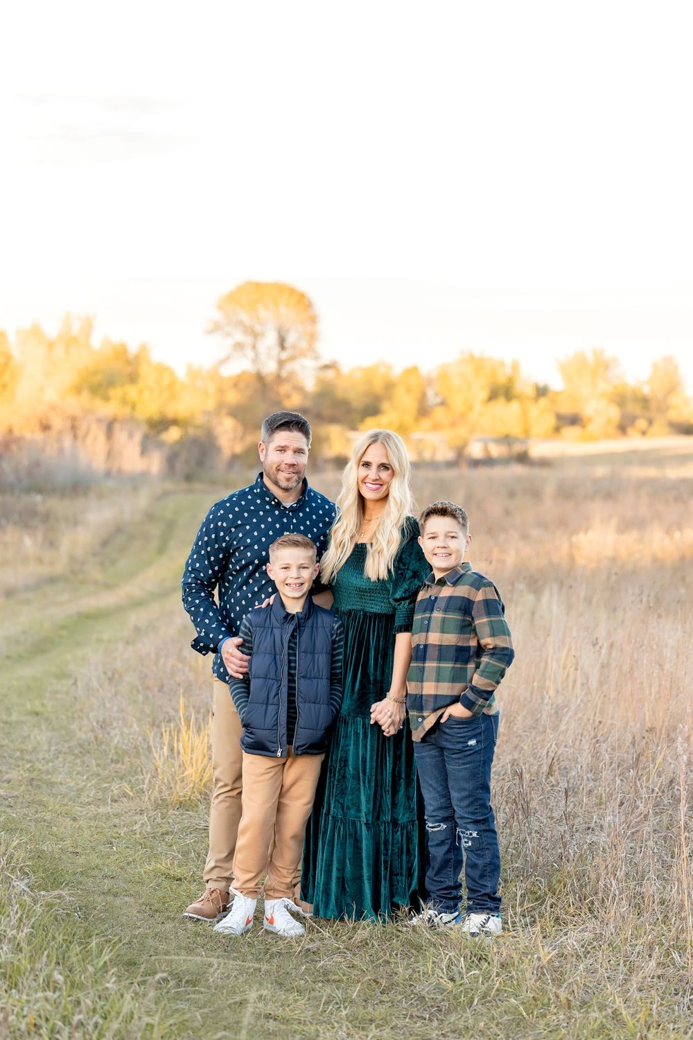 Family group photo in casual attire against autumn landscape. Clear Lake Photographer. Mason City Photographer.