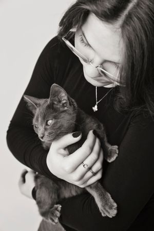 Tini lány cicájával egy fekete fehér képen