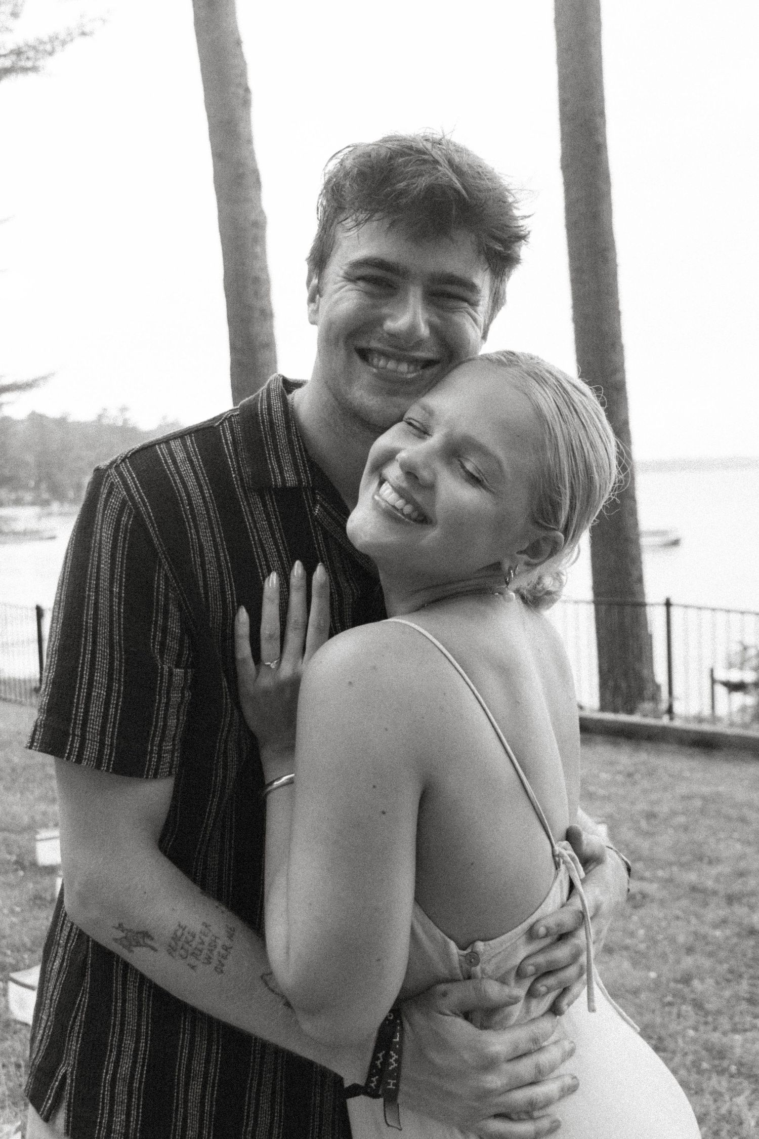 A candid black and white photo captures a joyful embrace between two people.
