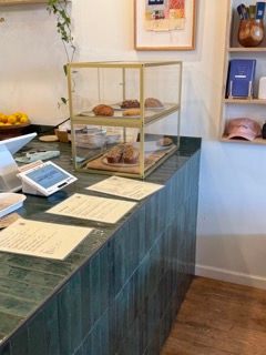 Restaurant counter with glass display case showing menu items and food.