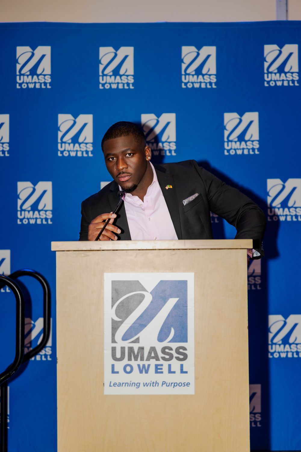 Speaker at podium with UMass Lowell branded backdrop.