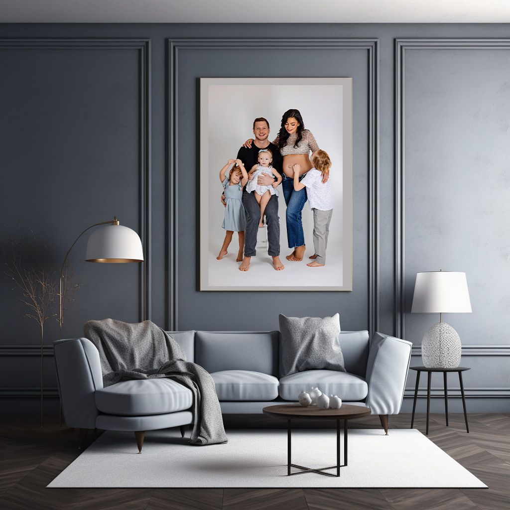 Modern living room interior with gray walls, upholstered sofa, wood flooring and large framed portrait on wall.