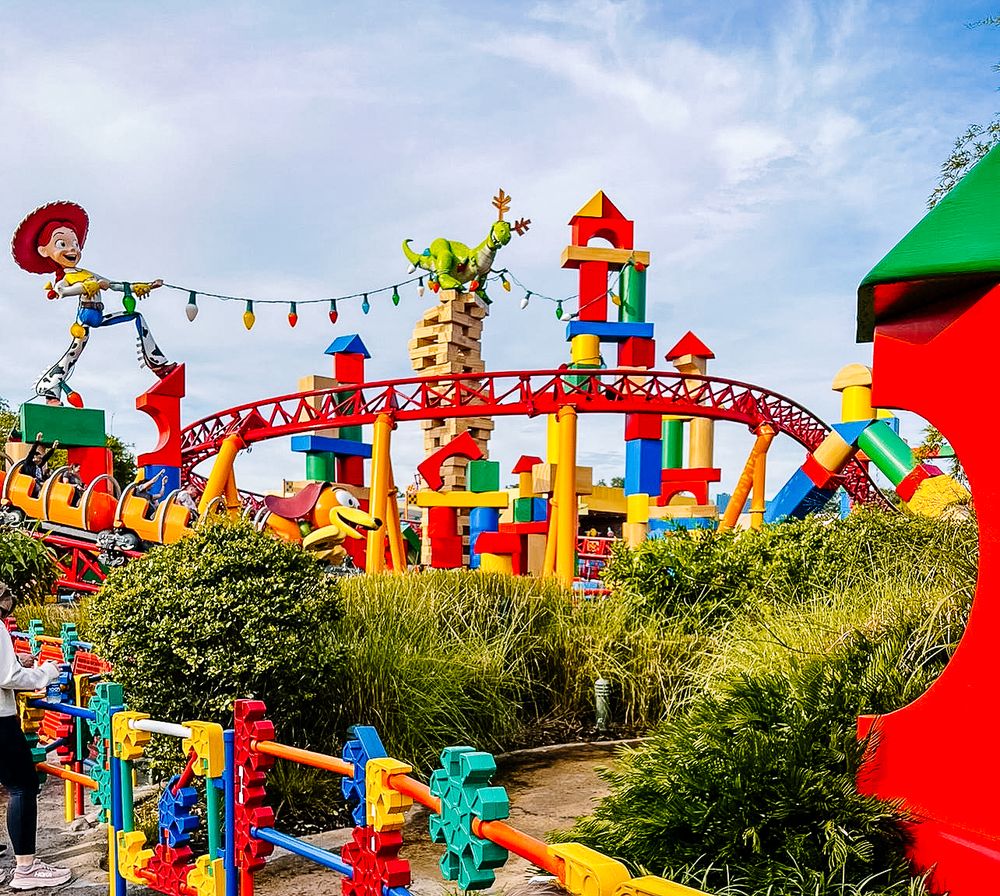 Colorful amusement park rides and vibrant decorations creating a whimsical panoramic view under bright blue sky.