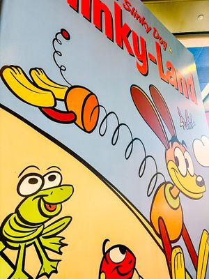 Colorful cartoon characters painted on a slanted white wall display vibrant yellow, red, and green designs.