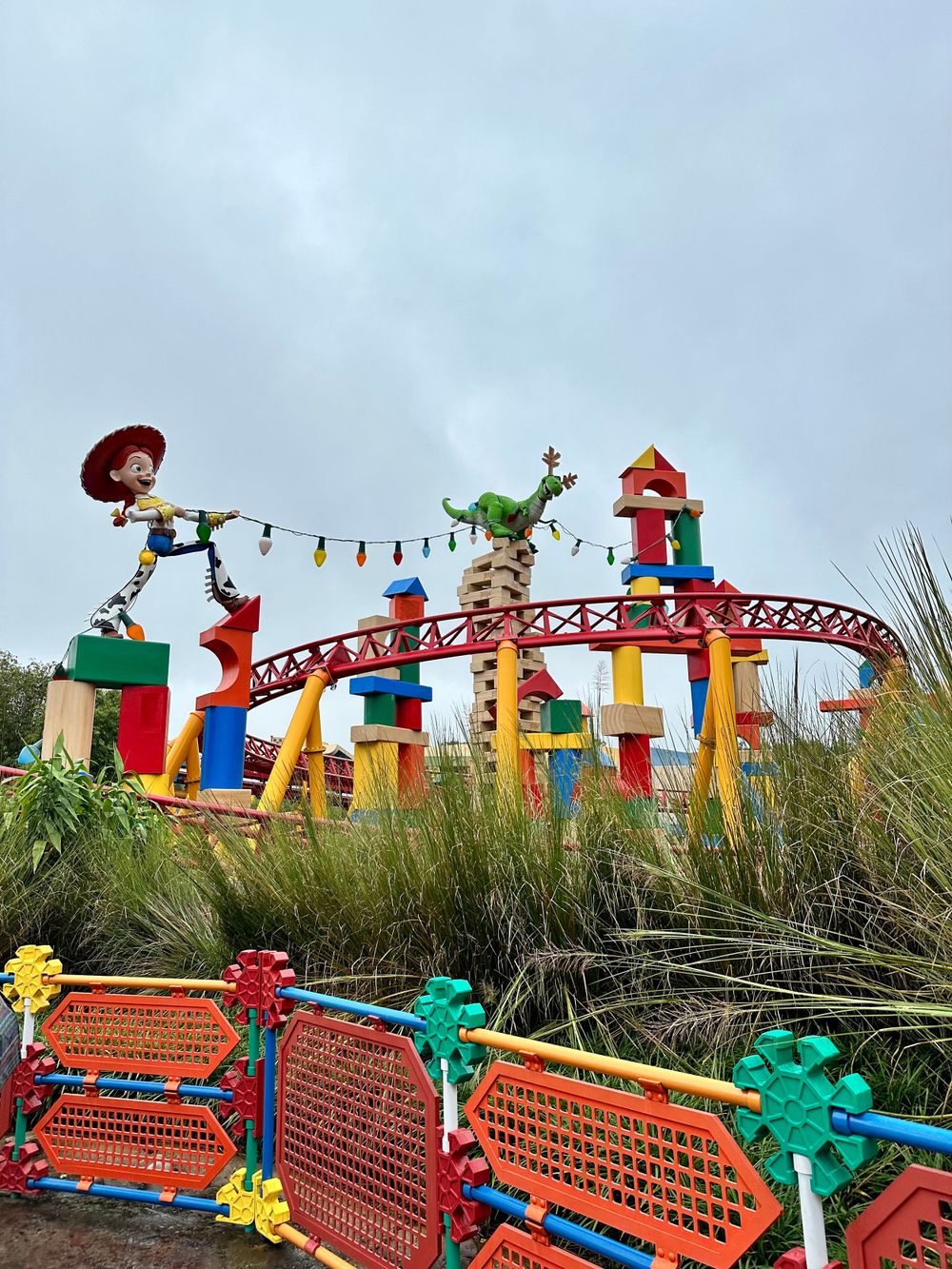 Colorful Toy Story-themed rollercoaster with Woody and Rex characters at Disney's Hollywood Studios theme park.