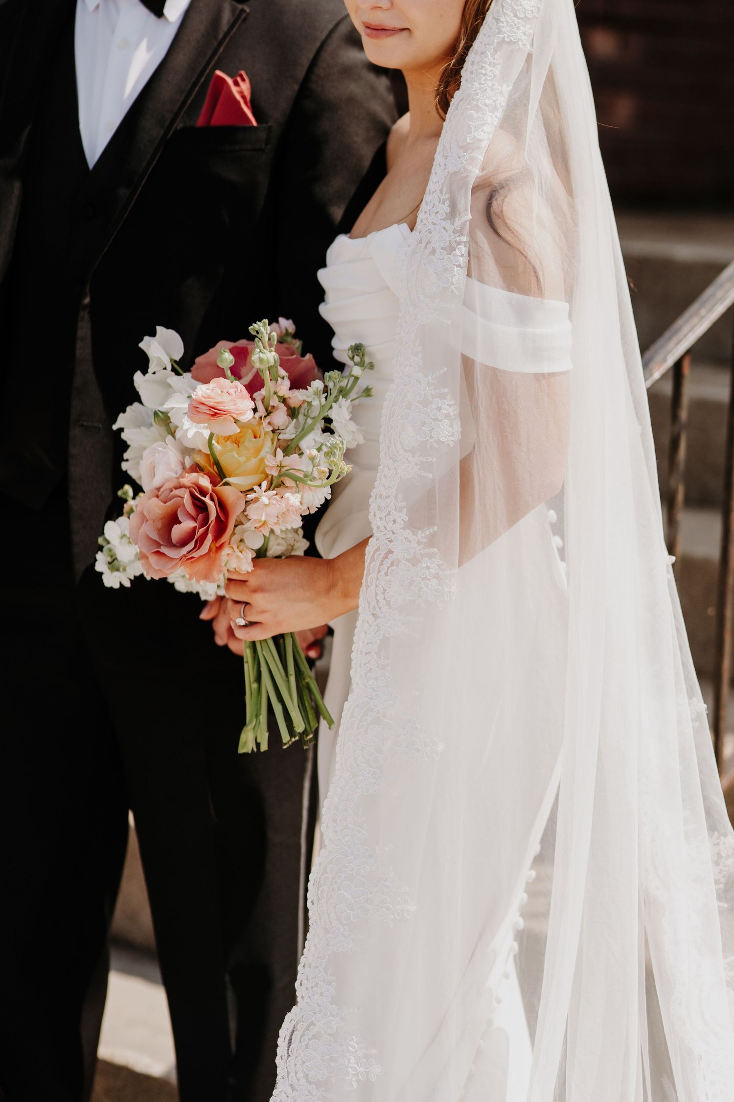 Wedding detail shots featuring a white veil, floral bouquet with peach and cream roses.