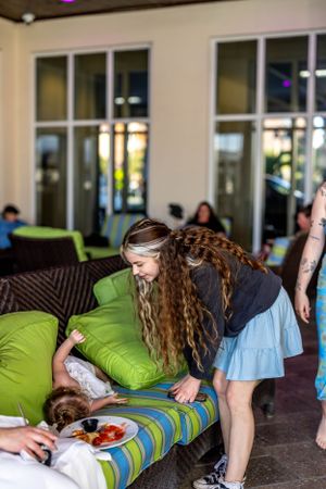 Group interacting near outdoor lounge area with bright green cushions.