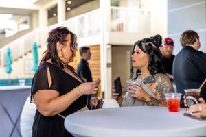 Two guests chatting enthusiastically while seated at an outdoor table.