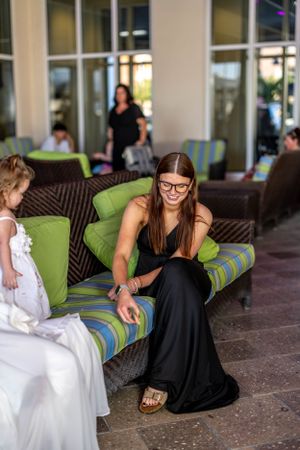 Social gathering on outdoor patio with wicker furniture and striped cushions.