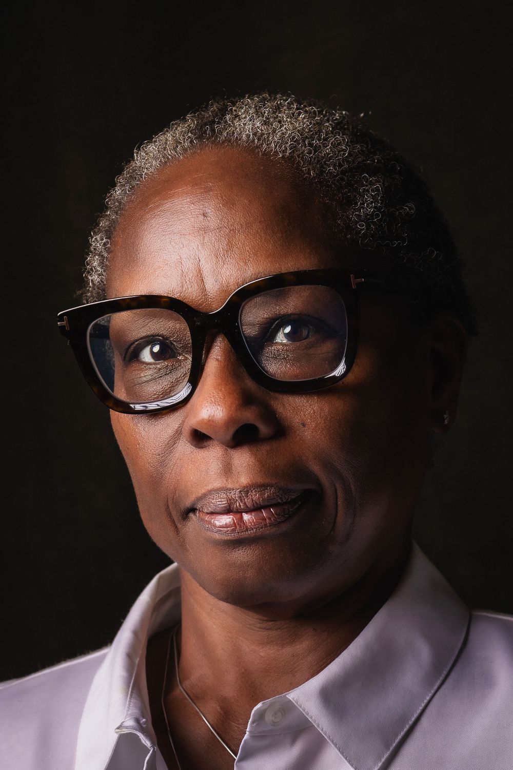 A series of expressive portrait photos showing someone in glasses and white shirt against a dark background.
