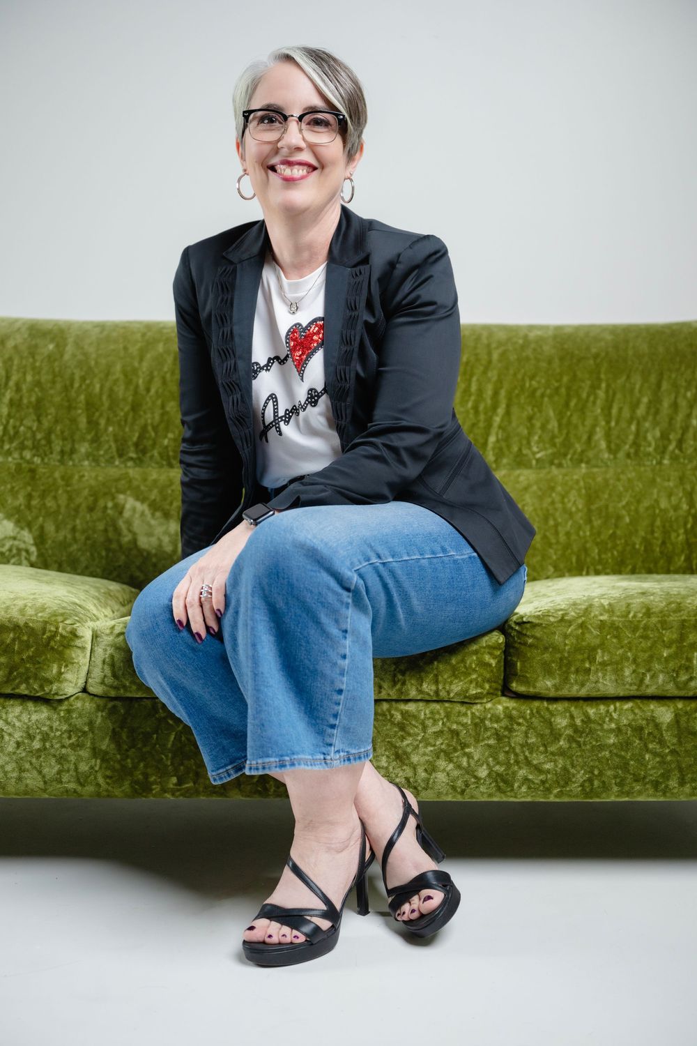 A series of photos showing a person in a black blazer and jeans sitting casually on a green velvet couch.