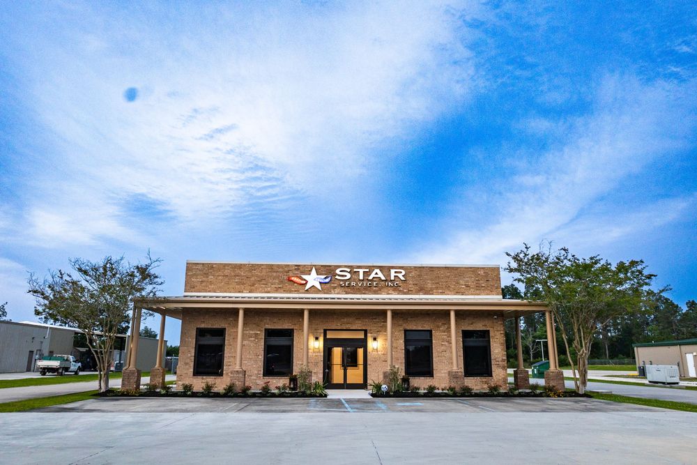 Panoramic view of a modern commercial building complex with tan exterior under blue skies.