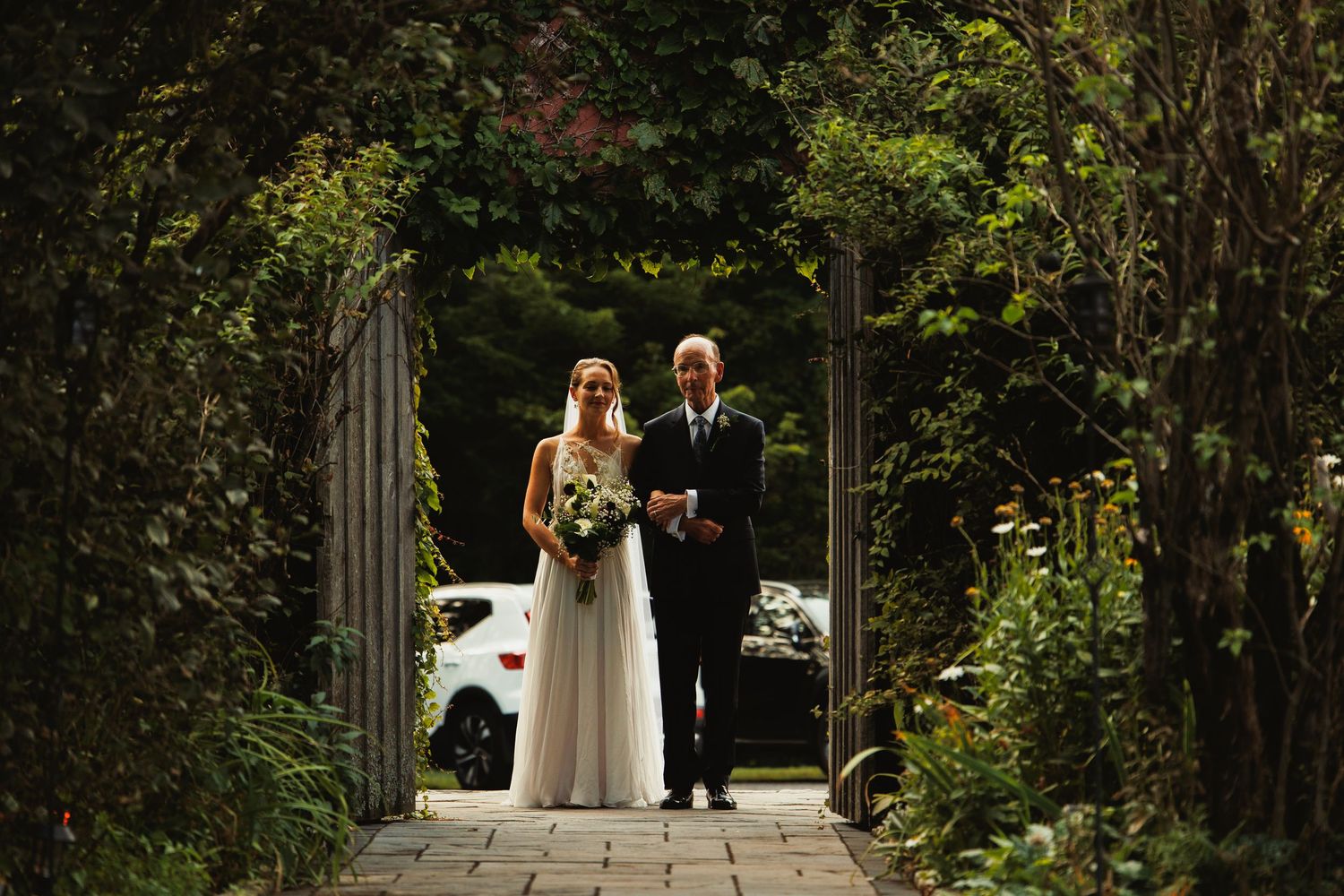 Garden wedding ceremony with floral decorations and natural greenery backdrop.