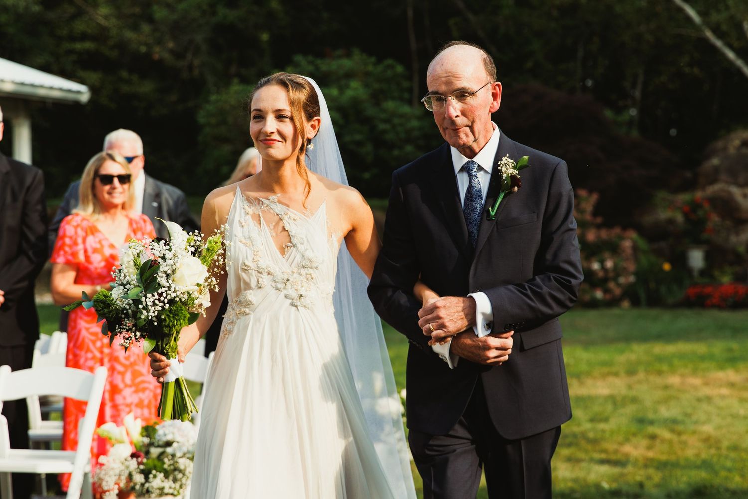 Wedding ceremony taking place outdoors with guests watching the exchange of vows.