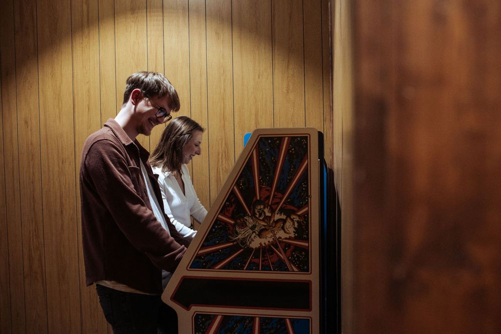 A romantic moment unfolds in front of a vintage window with wood paneling.