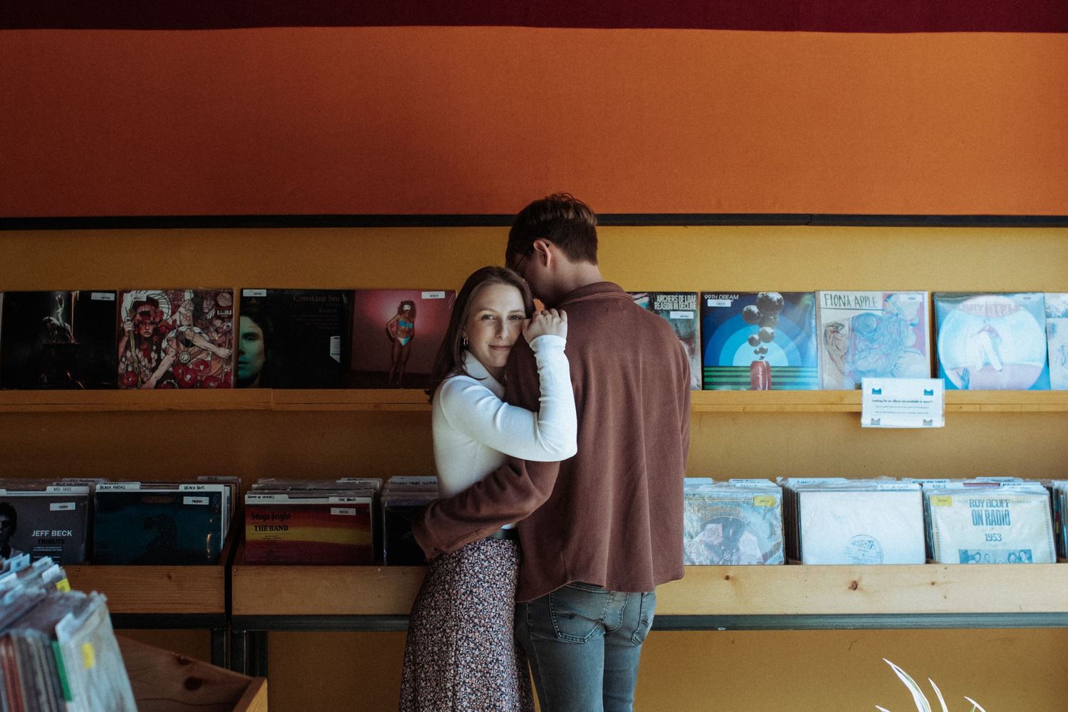 Panoramic view of a record store interior showing vinyl albums displayed on wooden shelves along the walls. Indianapolis, Indiana engagement