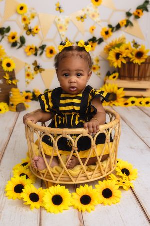 Beautiful baby girl celebrates her half birthday against a sunflower theme in studio, captured by Charlottesville newborn photographer.